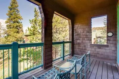 a porch with two chairs and a table and two windows at Soda Springs 3 Bedroom Townhome in Keystone