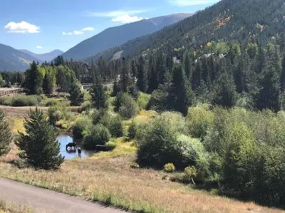 a river in a field with trees and a mountain at 1 Bedroom Condo In Keystone - West Keystone in Keystone