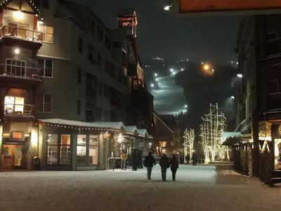 a group of people walking down a street at night at 1 Bedroom Condo In Keystone - West Keystone in Keystone