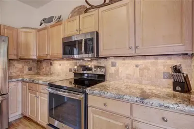 a kitchen with wooden cabinets and a stove and microwave at Northstar Townhomes In Keystone 2 Bedroom Rental in Keystone