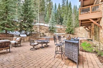 a patio with a table and chairs and a grill at 2 Bedroom Ski-In, Ski-Out Condo At The Timbers in Keystone