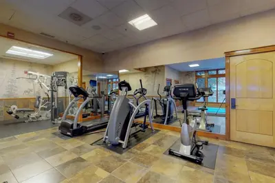 a gym with several treadmills and elliptical machines at 2 Bedroom Ski-In, Ski-Out Condo At The Timbers in Keystone