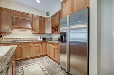 a kitchen with wooden cabinets and a stainless steel refrigerator at Lone Eagle 2 Bedroom Condo in Dillon