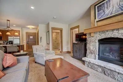 a living room with a stone fireplace and a couch at Lone Eagle 2 Bedroom Condo in Dillon