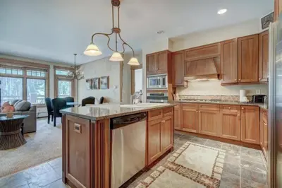 a kitchen with wooden cabinets and a living room at Lone Eagle 2 Bedroom Condo in Dillon