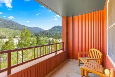 a balcony with two chairs and a view of the mountains at Silvermill Lodge 1 Bedroom In River Run Village in Keystone