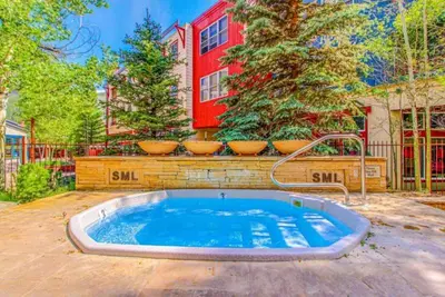 a swimming pool in front of a house with trees at Silvermill Lodge 1 Bedroom In River Run Village in Keystone