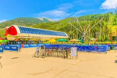 an amusement park with a ferris wheel and tables and umbrellas at Silvermill Lodge 1 Bedroom In River Run Village in Keystone