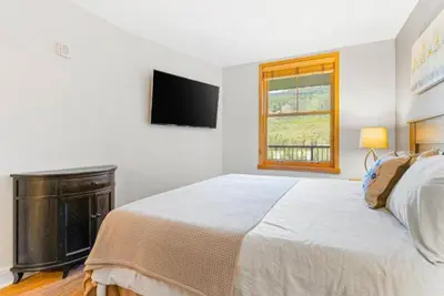 a white bedroom with a bed and a window at Silvermill Lodge 1 Bedroom In River Run Village in Keystone