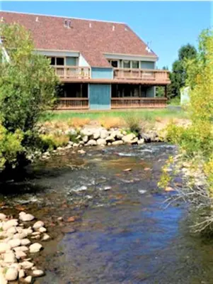 a house with a river in front of it at Twin Rivers By Alderwood Colorado Management in Fraser