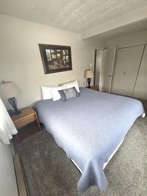 a bedroom with a large bed and two lamps at Twin Rivers By Alderwood Colorado Management in Fraser