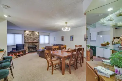a dining room and living room with a table and chairs at Mtn View Granby Condo with In-Unit Hot Tub! in Granby