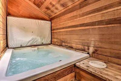a jacuzzi tub in a room with wooden walls at Mtn View Granby Condo with In-Unit Hot Tub! in Granby