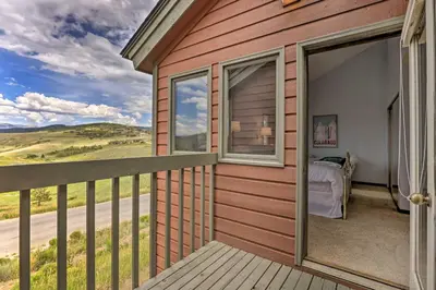 a house with a balcony with a bed and a window at Mtn View Granby Condo with In-Unit Hot Tub! in Granby