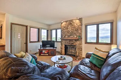 a living room with a couch and a fireplace at Mtn View Granby Condo with In-Unit Hot Tub! in Granby