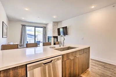 a kitchen with a sink and a living room at Hot Tub and Balcony Riverfront Silverthorne Condo! in Silverthorne