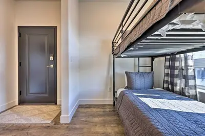 a bedroom with a bunk bed and a door at Hot Tub and Balcony Riverfront Silverthorne Condo! in Silverthorne