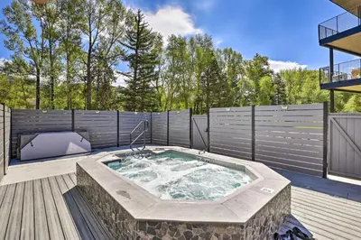 a hot tub on a deck with a fence at Hot Tub and Balcony Riverfront Silverthorne Condo! in Silverthorne