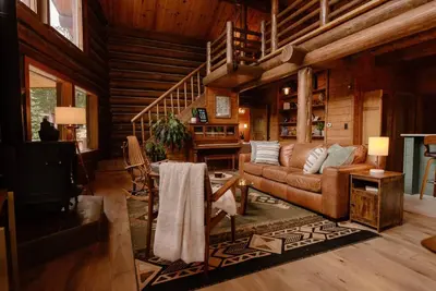 a living room with a couch and a table at Classic Log Cabin near Rocky Mountain National Park and near Skiing in Lyons