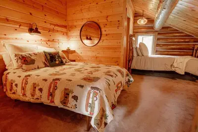 a bedroom with a bed in a log cabin at Classic Log Cabin near Rocky Mountain National Park and near Skiing in Lyons