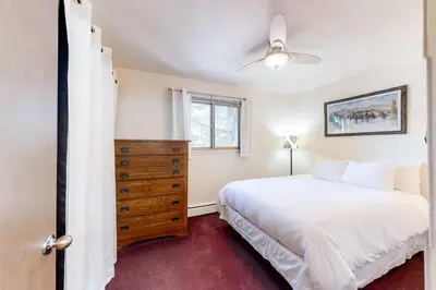 a bedroom with a white bed and a dresser at Hi Country 11-13 in Winter Park