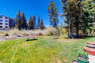 a park with a bench and a swing in the grass at Hi Country 11-13 in Winter Park