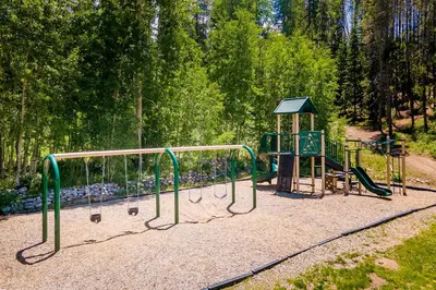 a playground in a park with a play equipment at Hi Country 11-13 in Winter Park