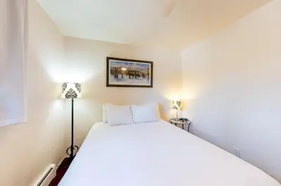 a bedroom with a large white bed with two lamps at Hi Country 11-13 in Winter Park