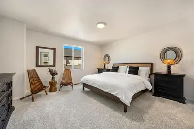 a bedroom with a bed and a dresser and a mirror at Modern Farmhouse Townhome - Great Central Location in Fort Collins