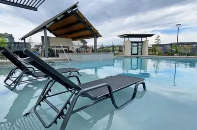 a swimming pool with two lounge chairs in the water at Modern Farmhouse Townhome - Great Central Location in Fort Collins