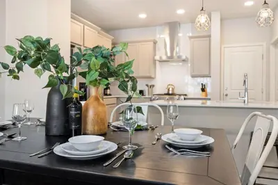 a kitchen with a table with plates and wine glasses at Modern Farmhouse Townhome - Great Central Location in Fort Collins