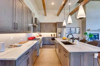 a large kitchen with wooden cabinets and a large island at Mountain Home with Hot Tub, Near WP Resort! in Winter Park