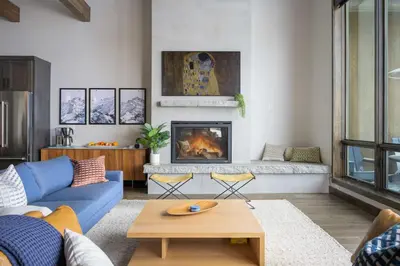 a living room with a blue couch and a fireplace at Mountain Home with Hot Tub, Near WP Resort! in Winter Park