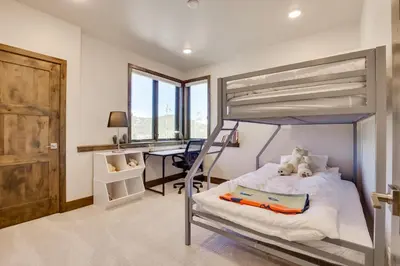 a bedroom with a bunk bed and a desk at Mountain Home with Hot Tub, Near WP Resort! in Winter Park