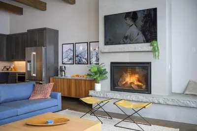 a living room with a blue couch and a fireplace at Mountain Home with Hot Tub, Near WP Resort! in Winter Park
