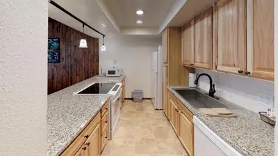 a large kitchen with wooden cabinets and a sink at Pines at Meadow Ridge in Fraser
