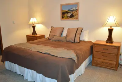 a bedroom with a bed with two night stands and two lamps at Pines at Meadow Ridge in Fraser