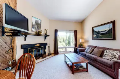 a living room with a couch and a fireplace at Vasquez Vista in Winter Park