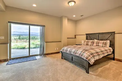 a bedroom with a bed and a large window at Game Room and Hot Tub Luxe Grand Lake Retreat! in Grand Lake