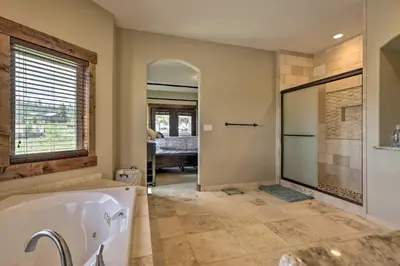 a bathroom with a tub and a walk in shower at Game Room and Hot Tub Luxe Grand Lake Retreat! in Grand Lake