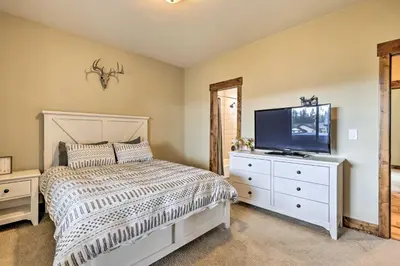a bedroom with a bed and a flat screen tv at Game Room and Hot Tub Luxe Grand Lake Retreat! in Grand Lake