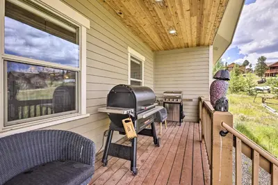 a house with a grill on a porch at Game Room and Hot Tub Luxe Grand Lake Retreat! in Grand Lake
