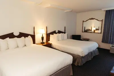 a hotel room with two beds and a mirror at The Boulder Broker in Boulder