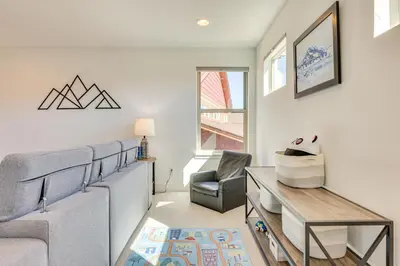 a living room with a couch and a chair at Furnished Deck and Hot Tub Chic Granby Home! in Granby