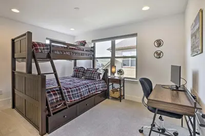 a bedroom with a bunk bed and a desk with a computer at Furnished Deck and Hot Tub Chic Granby Home! in Granby