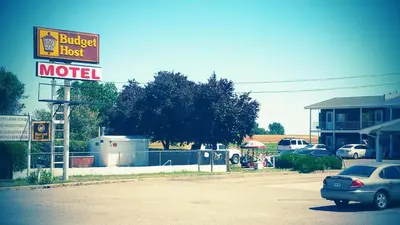 a motel sign with a car parked in a parking lot at Budget Host Exit 254 Inn in Loveland