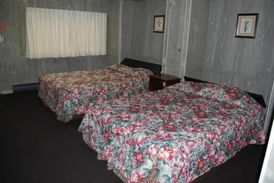 two beds in a hotel room with two beds sidx sidx sidx at Budget Host Exit 254 Inn in Loveland