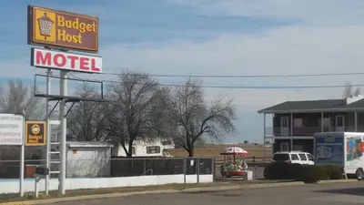 a motel sign in front of a gas station at Budget Host Exit 254 Inn in Loveland