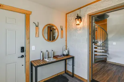 a hallway with a table and a mirror on a wall at The View at Mountain Retreat By Red Rocks and Golden in Evergreen