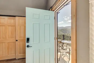 a door leading to a balcony with a table at The View at Mountain Retreat By Red Rocks and Golden in Evergreen
